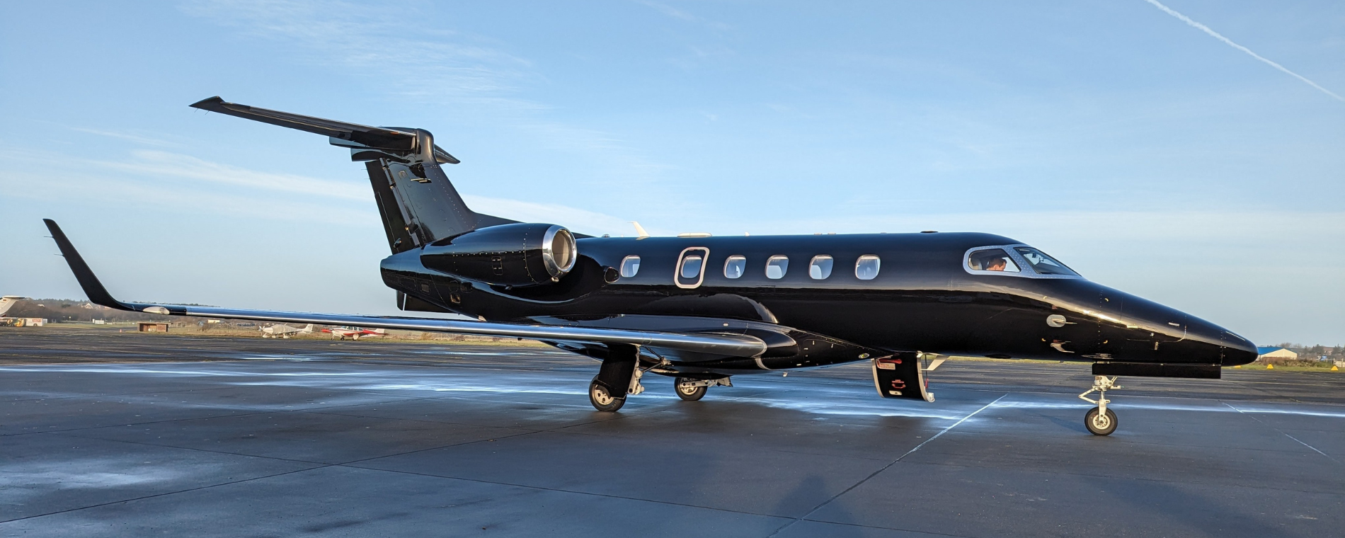 first private jet charter, black aircraft on tarmac