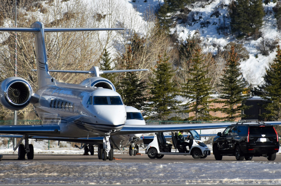 Private jet and chauffeur car on runway