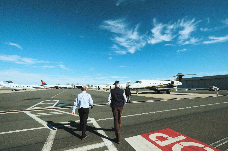 multi-destination trips by private jet. people walking on tarmac at airport towards private jet.
