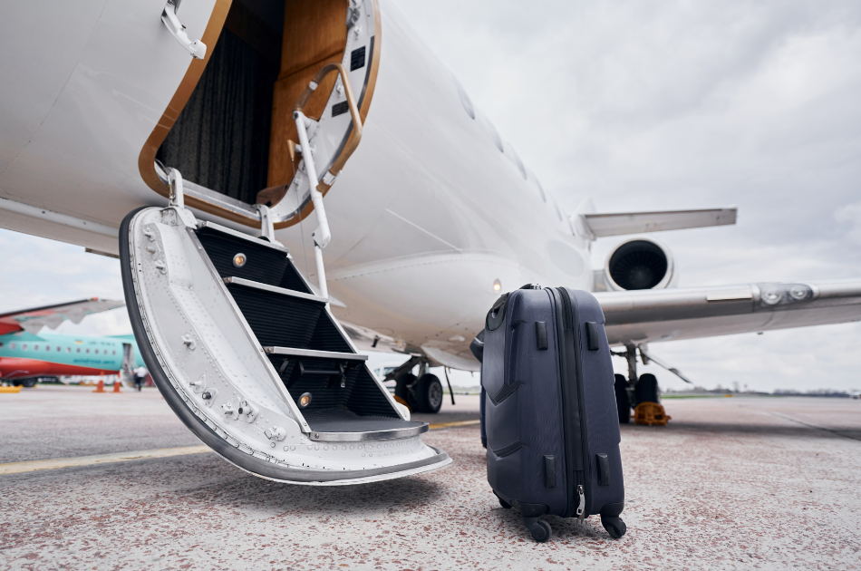 family travel suitcase outside of private jet steps
