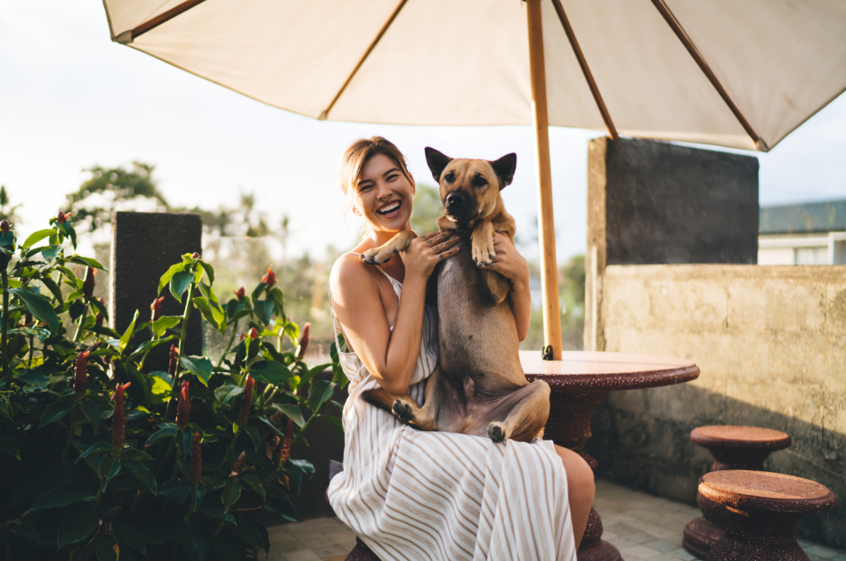 woman sitting down holding dog on rooftop terrace